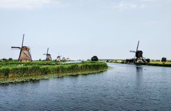 Mulini a vento olandesi e fiamminghi in riva a un fiume